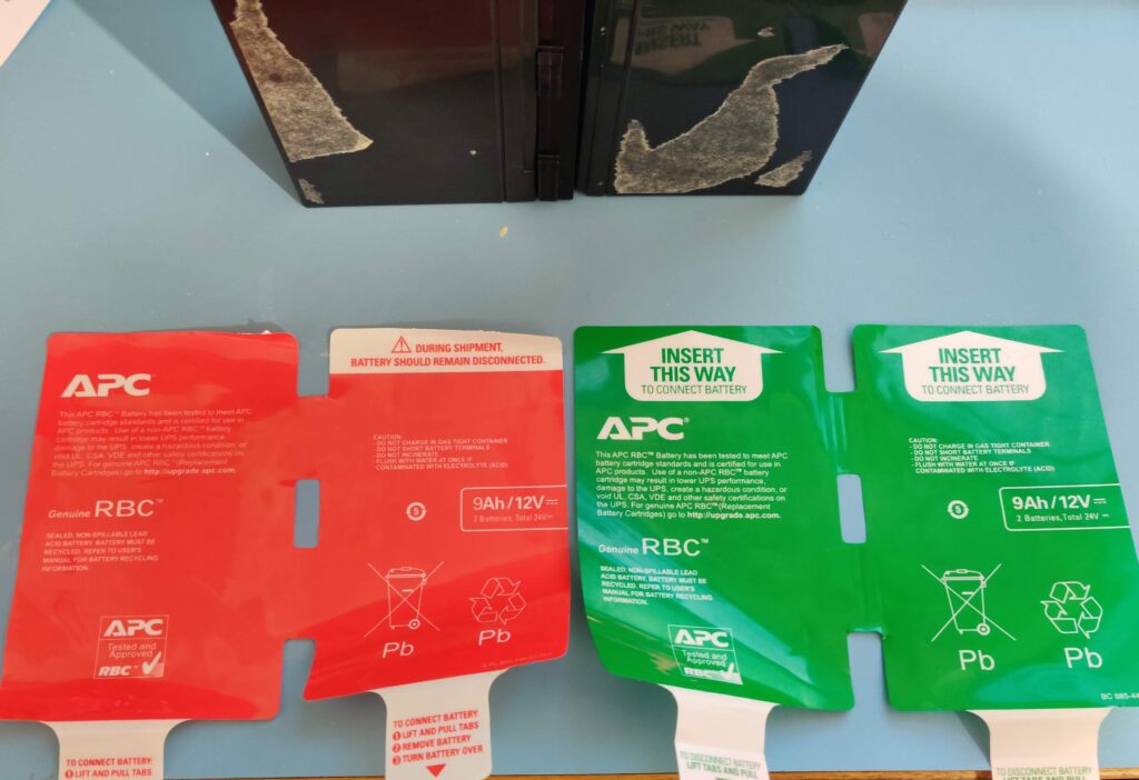 Both sticker plates peeled off and laid flat, one red and one green, with the bare cells standing behind them
